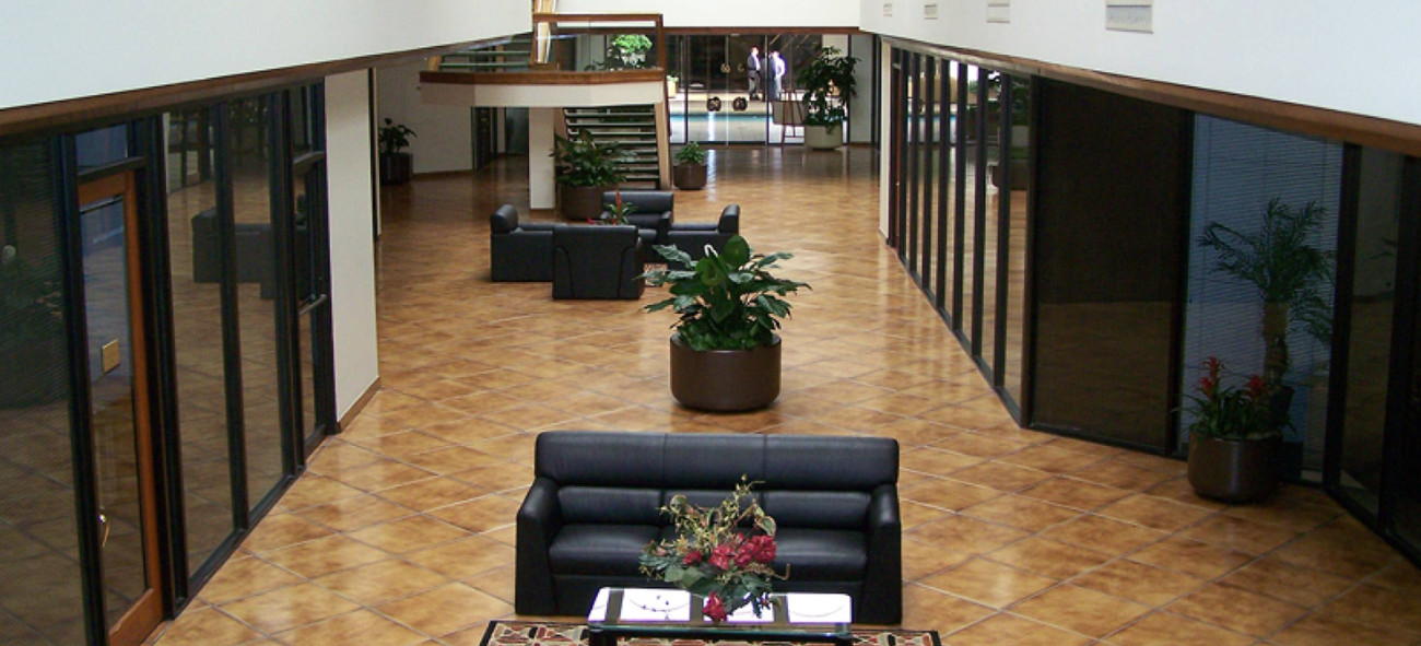 Atrium lounge inside the 11111 Wilcrest Green Dr office building, with seating areas and greenery